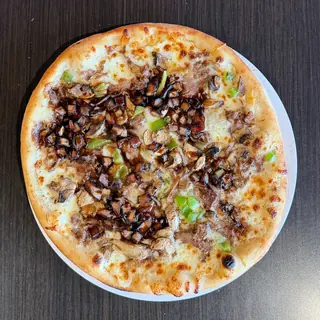The Steak Bake, a Longshot specialty pizza seen from above: white Garlic Sauce, Mozzarella & Provolone, Shaved Steak, Mushroom, Green Pepper, Balsamic Onions, Asiago, on a blistered brick-oven crust